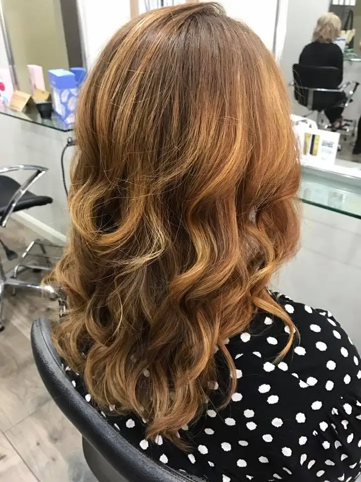 Copper-brown hair styled in loose curls