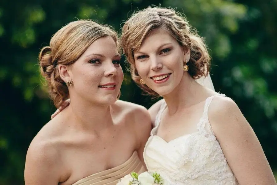 Bride and bridesmaid with formal upstyled hair for a wedding