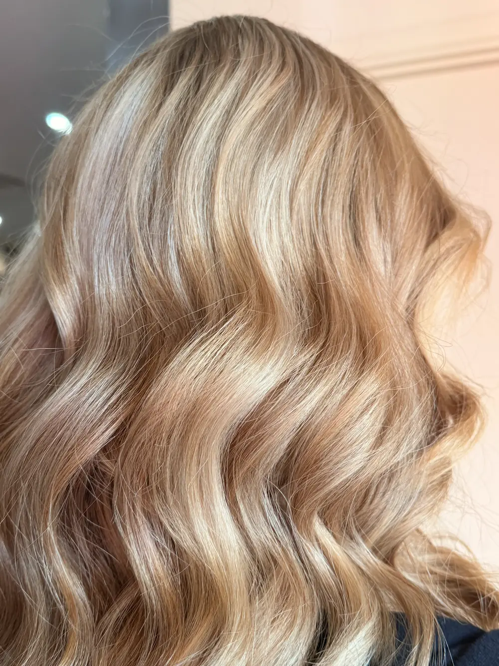 Blonde hair with soft waves and dimensional highlights