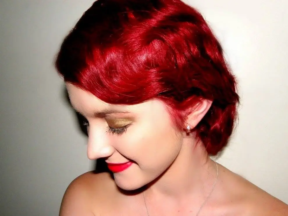 Short glossy red hair styled in a smooth side-swept shape